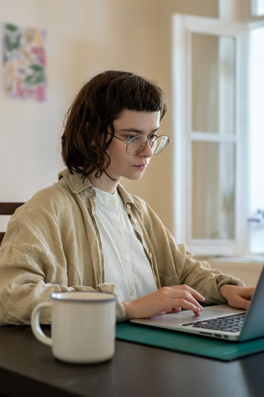 Concentrated teenager working, studying with laptop computer in comfortable conditions at home
