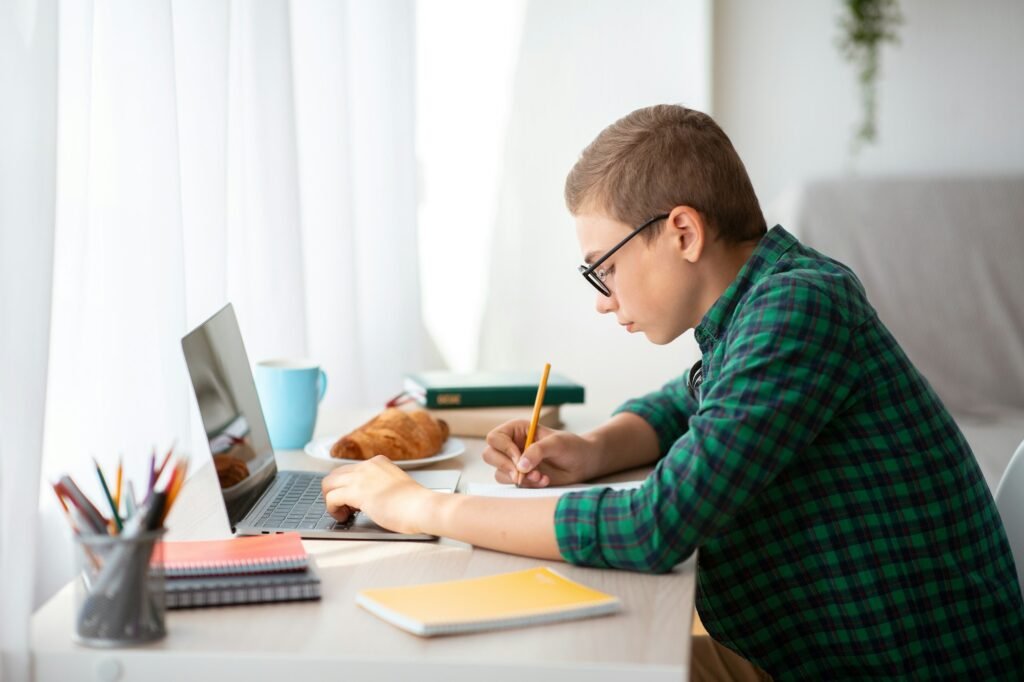 Teenager working hard on homework, online education